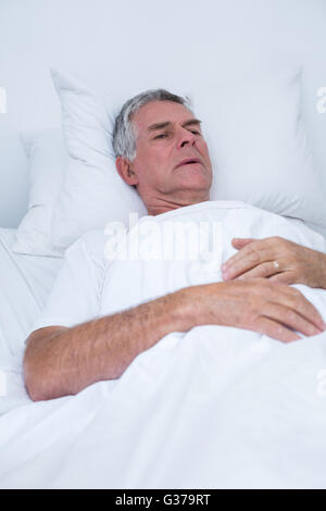 Senior woman auf Bett liegend Stockfoto