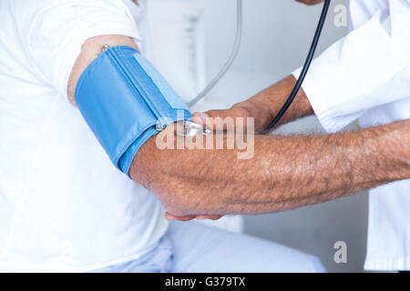 Arzt überprüft Senior mans Blutdruck Stockfoto