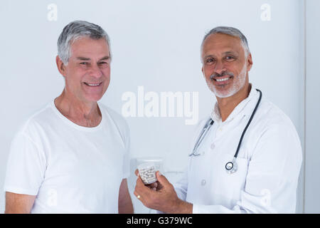 Porträt von männlichen Arzt senior woman Pillen geben Stockfoto