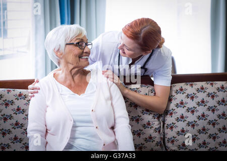 Arzt im Gespräch mit eine glückliche senior Frau lächelnd Stockfoto