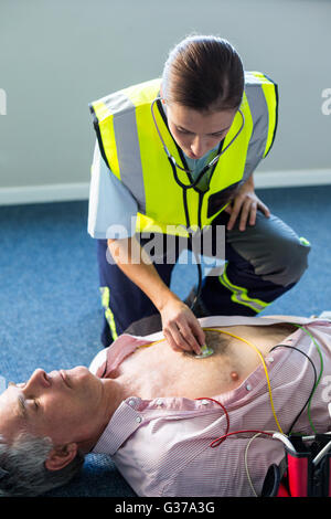 Rettungssanitäter Prüfung eines Patienten während der kardiopulmonalen Reanimation Stockfoto