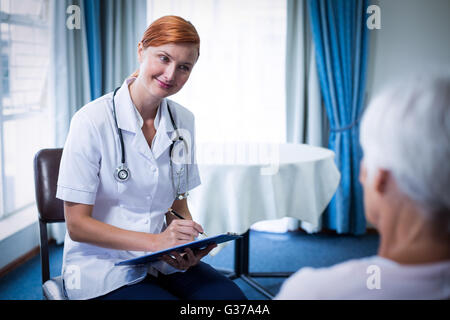 Lächelnde Arzt Rücksprache mit älteren Frau Stockfoto