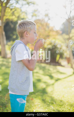 Kleiner Junge bläst Seifenblasen durch Blase Zauberstab Stockfoto