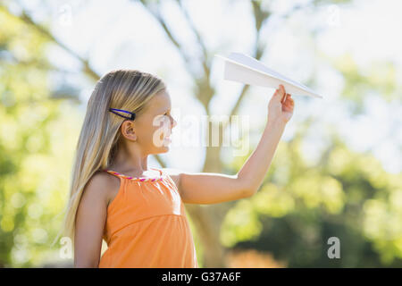 Junge Mädchen spielen mit einem Papierflieger Stockfoto