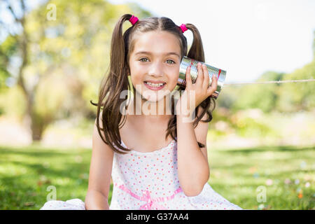 Junges Mädchen hören über Telefon Blechdose Stockfoto