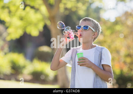 Kleiner Junge bläst Seifenblasen durch Blase Zauberstab Stockfoto