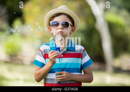 Kleiner Junge in Sonnenbrille Seifenblasen durch Blase Zauberstab Stockfoto