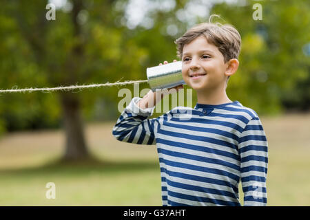 Junge hören über Telefon Blechdose Stockfoto