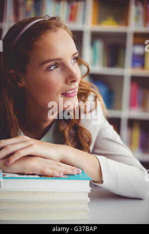 Nachdenklichen Lehrer mit Büchern in der Bibliothek Stockfoto