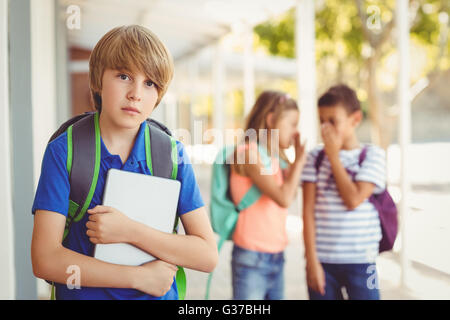 Schulfreunde Mobbing einen traurigen jungen im Korridor Stockfoto