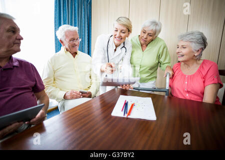 Krankenschwester mit Senioren etwas Stockfoto