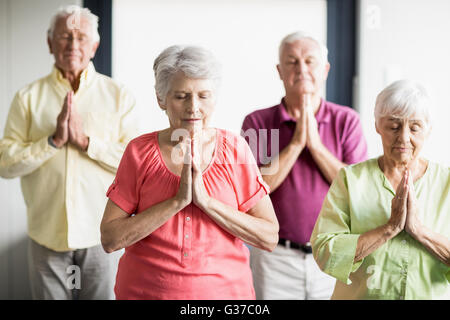 Senioren Yoga mit geschlossenen Augen machen Stockfoto