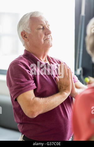 Senioren Yoga mit geschlossenen Augen machen Stockfoto