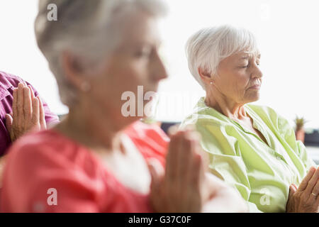 Senioren Yoga mit geschlossenen Augen machen Stockfoto