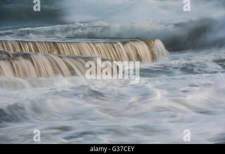 Mächtige Meereswellen am Meer rock-Platten schaffen kleine Wasserfälle Stockfoto