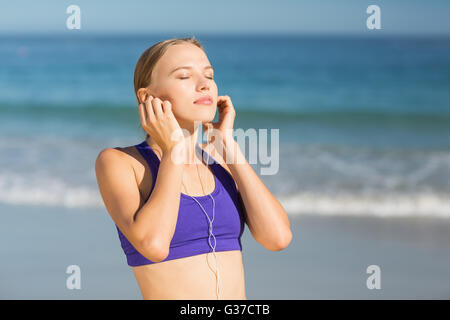 Schöne junge Frau Musik hören während des Trainings Stockfoto