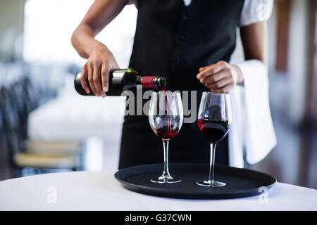 Mittleren Bereich der Kellnerin Rotwein in ein Glas gießen Stockfoto