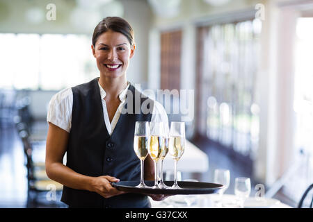 Porträt der Kellnerin holding Serviertablett mit Champagner flutesB Stockfoto
