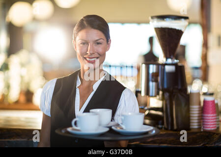 Porträt der Kellnerin hielt ein Tablett mit Kaffeetassen Stockfoto