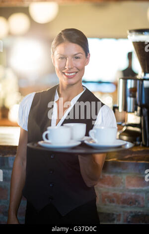 Porträt der Kellnerin hielt ein Tablett mit Kaffeetassen Stockfoto