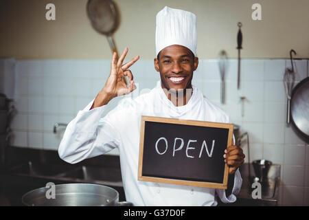 Lächelnd Chef zeigt Tafel mit Schild "geöffnet" Stockfoto