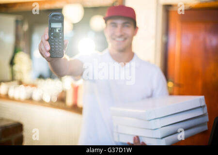 Pizza Lieferung Mann Betrieb Telefon Stockfoto