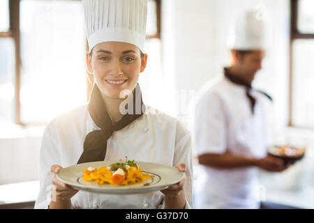 Glücklich Chefkoch präsentiert ihr Essen Stockfoto