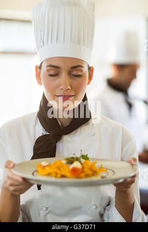 Nahaufnahme des Küchenchefs mit Augen geschlossen riechenden Lebensmitteln Stockfoto