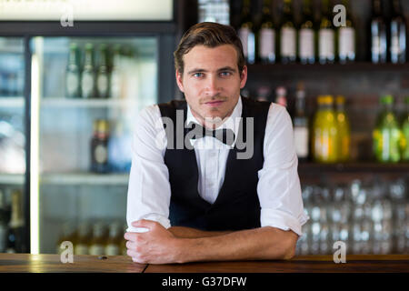 Porträt von Bartender stützte sich auf Bartheke Stockfoto