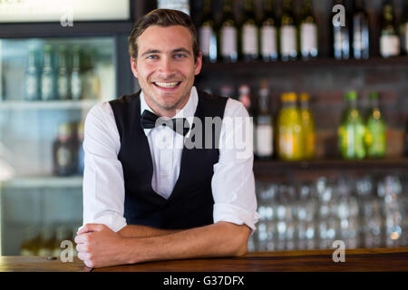 Porträt von Bartender stützte sich auf Bartheke Stockfoto