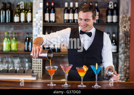 Barkeeper Gießen einen orangenen Martini trinken im Glas Stockfoto