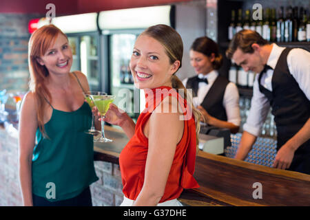 Porträt von Freunden halten einen Cocktail vor der Theke Stockfoto