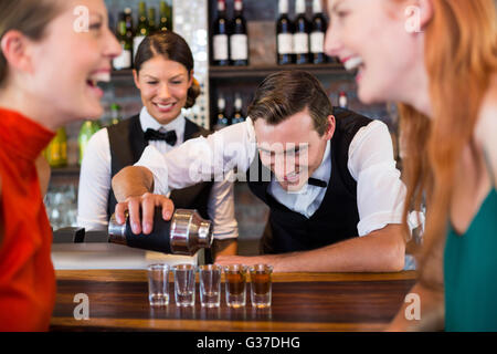 Barkeeper Gießen Tequila in Schnapsgläser Stockfoto