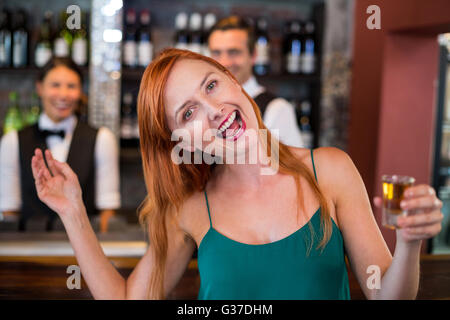 Portrait von betrunkenen Frau mit Tequila erschossen vor Theke lachen Stockfoto