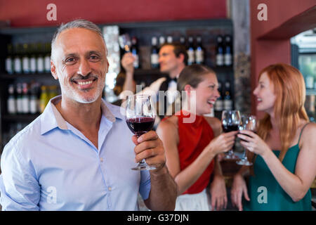 Porträt von lächelnder Mann mit Glas Rotwein Stockfoto