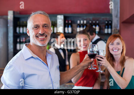 Porträt von Freunden bei einem Glas Rotwein in einer Bar Toasten Stockfoto