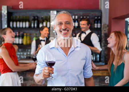 Porträt des Mannes mit einem Glas Wein vor der Theke Stockfoto