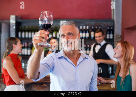 Mann mit einem Glas Rotwein in einer Bar Toasten Stockfoto