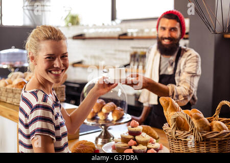 Kellner mit einem Kaffee an einem Kunden Stockfoto