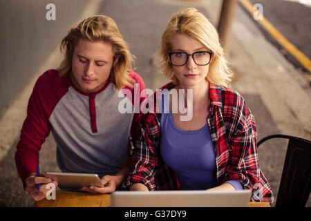 Paar mit einem Laptop und einem Tablet-Computer auf der Außenterrasse Stockfoto