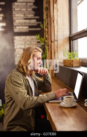 Junger Mann mit Laptop in cafeteria Stockfoto