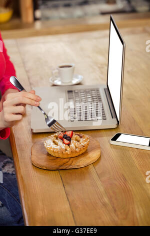 Frau einen Kuchen alleine essen Stockfoto