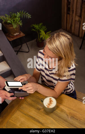 Frau mit mobile-Payment bezahlen Stockfoto