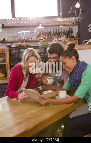 Freunde mit einer Tablet-Sitzung Stockfoto