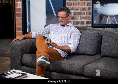 Geschäftsmann sucht seinen Tablettcomputer Stockfoto
