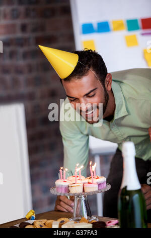 Porträt des Kaufmanns Ausblasen der Kerzen zum Geburtstag Stockfoto