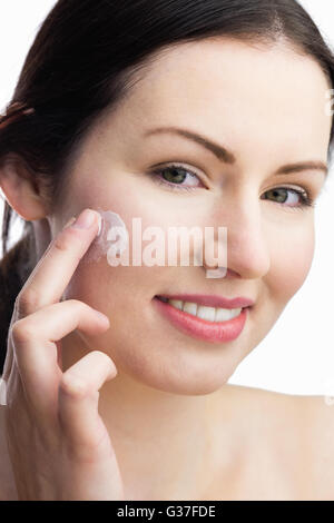 Frau Auftragen einer Creme Stockfoto