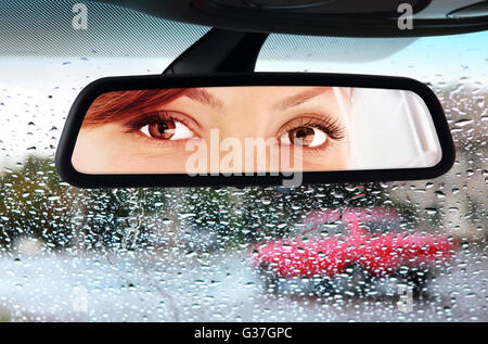 Frau sitzt auf Fahrersitz und schaut in den Rückspiegel Stockfotografie -  Alamy