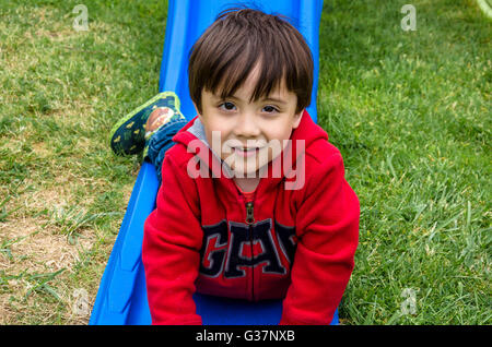 Ein Portrait eines jungen Mannes, der gerade Kopf erst nach unten Garten Rutsche gerutscht ist. Stockfoto