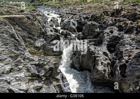 Wasserfall fließt zwischen die Lavasteine, sonnigen Tag Stockfoto